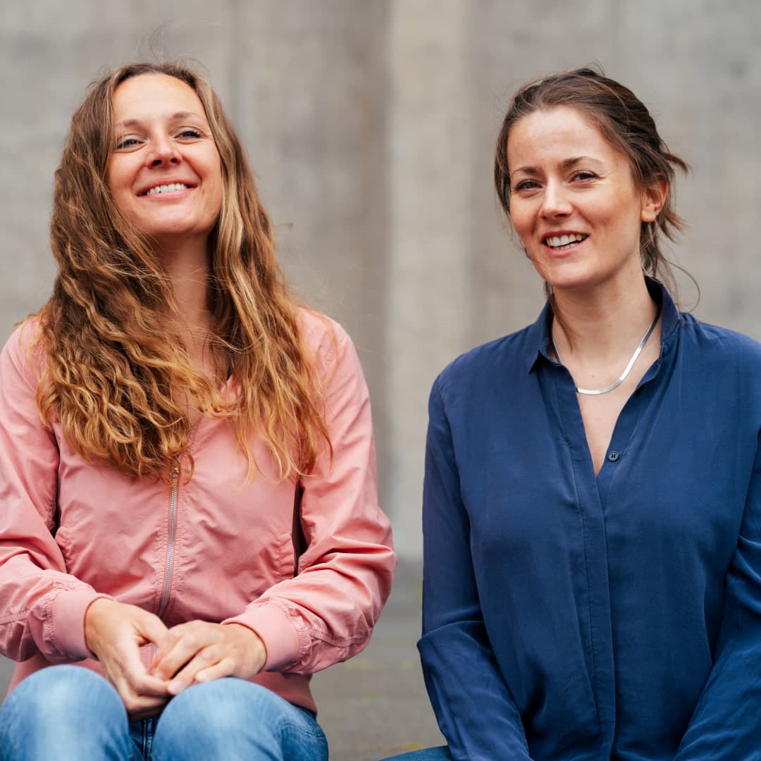 &done Charlotte Widegreen und Cora Thielen in urbaner Umgebung auf einer Treppe sitzend.